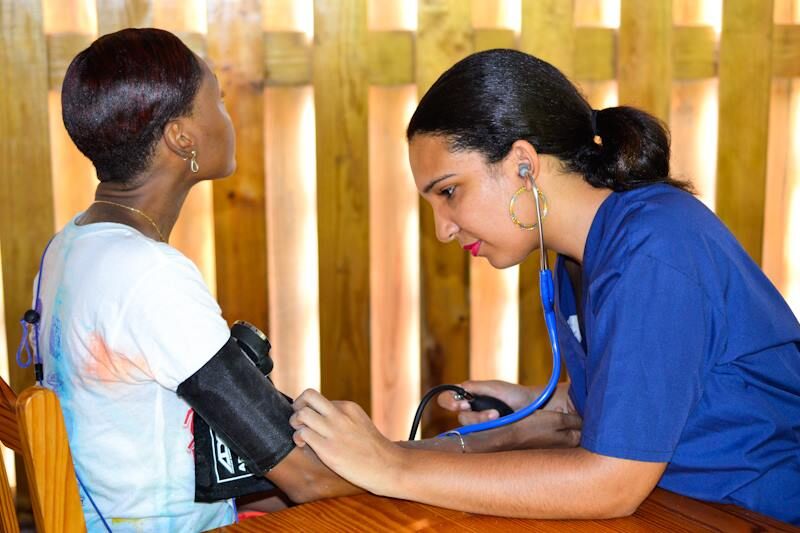 Trinity medical school students assist local patient by checking blood pressure